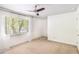 Bright bedroom features a ceiling fan and a window with natural light streaming in through sheer, white curtains at 6940 Roswell Road Rd # 16B, Atlanta, GA 30328
