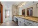 Bathroom featuring a granite countertop, mirrored vanity, and an inviting natural light-filled hallway at 705 S Bethany Rd, Mcdonough, GA 30252