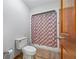 Functional bathroom with a standard toilet, shower, and neutral-colored tile flooring at 705 S Bethany Rd, Mcdonough, GA 30252