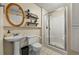 Bathroom featuring a pedestal sink, stand-up shower, shelving, and a framed mirror at 705 S Bethany Rd, Mcdonough, GA 30252