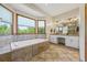 Luxurious bathroom featuring a large soaking tub, double vanity, and tiled floors at 705 S Bethany Rd, Mcdonough, GA 30252