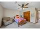 Cozy bedroom featuring a ceiling fan, comfortable armchair, and traditional wooden closet at 705 S Bethany Rd, Mcdonough, GA 30252