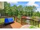 Wood deck with blue cushioned bench overlooking tree-lined backyard at 705 S Bethany Rd, Mcdonough, GA 30252