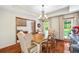 Elegant dining room featuring hardwood floors, a chandelier, large windows, and a beautiful wood table at 705 S Bethany Rd, Mcdonough, GA 30252