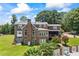 Exterior view of a brick home with landscaped yard, chimney and an above-garage bonus space at 705 S Bethany Rd, Mcdonough, GA 30252