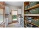 Bright laundry room with modern washer and dryer, sink, tiled flooring, shelving, and view to the backyard at 705 S Bethany Rd, Mcdonough, GA 30252