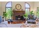 Inviting living room showcasing a cozy brick fireplace, hardwood floors and arched windows at 705 S Bethany Rd, Mcdonough, GA 30252
