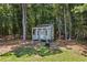 A small garden shed with white trim sits amid tall trees at 705 S Bethany Rd, Mcdonough, GA 30252
