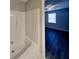 Bright bathroom showcasing a white tub, and a glimpse into an adjacent bedroom with ceiling fan and window at 365 Wesley Mill Pl, Villa Rica, GA 30180