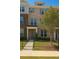 Charming three-story townhome featuring a brick facade, a well-manicured lawn, and a black metal fence at 559 Fundao Ln # 21, Lawrenceville, GA 30046