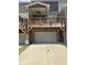 Rear view of townhome with a two-car garage, wooden deck, and a concrete driveway at 559 Fundao Ln # 21, Lawrenceville, GA 30046