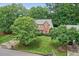 Aerial view of a lovely home with green lawn and surrounded by lush trees and landscaping at 1065 Bookhout Drive Dr, Cumming, GA 30041