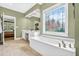 Bright bathroom featuring a soaking tub and decorative window at 1065 Bookhout Drive Dr, Cumming, GA 30041