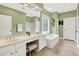 Bathroom featuring dual sinks, garden tub, tile floors, and lots of natural light at 1065 Bookhout Drive Dr, Cumming, GA 30041