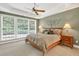 Comfortable bedroom with large windows, tray ceiling, ceiling fan, and neutral decor at 1065 Bookhout Drive Dr, Cumming, GA 30041