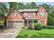 Charming two-story brick home with a well-manicured lawn and a two-car garage at 1065 Bookhout Drive Dr, Cumming, GA 30041