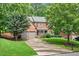 Traditional brick home featuring a two-car garage and a beautifully landscaped front yard at 1065 Bookhout Drive Dr, Cumming, GA 30041