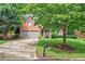Inviting two-story brick home with a lush green lawn and mature trees at 1065 Bookhout Drive Dr, Cumming, GA 30041