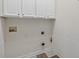 Laundry hookups ready to go with upper cabinets and tile flooring at 1065 Bookhout Drive Dr, Cumming, GA 30041