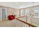 Bright loft area featuring a red armchair, ceiling fan, and staircase access at 1065 Bookhout Drive Dr, Cumming, GA 30041