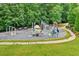 Community playground with swings, slides, and benches surrounded by lush greenery and ample space for recreational activities at 1065 Bookhout Drive Dr, Cumming, GA 30041