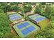 Aerial view of multiple, well-maintained community tennis courts surrounded by lush greenery at 1065 Bookhout Drive Dr, Cumming, GA 30041