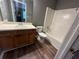 Bathroom with wood vanity, sink, mirror, and bathtub/shower insert at 5768 Windgate Ln, Lithonia, GA 30058