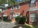 Brick townhouse exterior with white windows, shutters and door, complimented with green shrubs at 5768 Windgate Ln, Lithonia, GA 30058