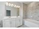 Bathroom featuring a double sink vanity, large mirror and tiled shower with a tub at 621 Hanlon Way, Alpharetta, GA 30009