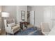 Calm bedroom featuring neutral tones, accent chair, a blue rug, and plenty of natural light at 621 Hanlon Way, Alpharetta, GA 30009