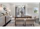 A dining room has a modern chandelier, a dark wood table, neutral colored chairs, and a sideboard at 621 Hanlon Way, Alpharetta, GA 30009