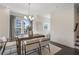 Bright dining room featuring a modern chandelier, a dark wood table, and neutral-colored chairs and rug at 621 Hanlon Way, Alpharetta, GA 30009