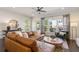 Inviting living room features a brown leather sectional, wood floors, and a view of the outdoor deck at 621 Hanlon Way, Alpharetta, GA 30009