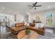 Spacious living room with a brown leather sectional, hardwood floors, and an open layout into the kitchen at 621 Hanlon Way, Alpharetta, GA 30009