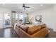 Bright living room featuring a brown leather sectional, hardwood floors, and a door to an outdoor deck at 621 Hanlon Way, Alpharetta, GA 30009