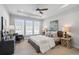 A tray ceiling, ceiling fan, and large windows grace the main bedroom featuring a king bed at 621 Hanlon Way, Alpharetta, GA 30009