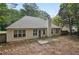 Back exterior of home with light siding, windows, chimney, and patio, surrounded by trees and greenery at 288 Old Burnt Hickory Rd, Acworth, GA 30101