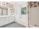 Full bathroom with soaking tub, shower, and double vanity with storage at 288 Old Burnt Hickory Rd, Acworth, GA 30101