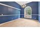 Dining room with blue walls, white trim, chandelier, and a large arched window at 288 Old Burnt Hickory Rd, Acworth, GA 30101