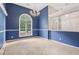 Spacious dining room with blue walls, chandelier, and an arched window overlooking the yard at 288 Old Burnt Hickory Rd, Acworth, GA 30101