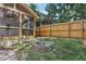 Charming backyard featuring a stone fire pit, wooden fence, and a screened-in porch perfect for outdoor living at 1633 Woodbine Ne Ave, Atlanta, GA 30317