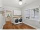 Convenient laundry room with modern washer/dryer, storage cabinets, and natural light near an open kitchen at 1633 Woodbine Ne Ave, Atlanta, GA 30317