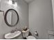 Powder room features a pedestal sink, decorative mirror, and a toilet with tissue holder at 2719 Hedgeway Cir, Kennesaw, GA 30144