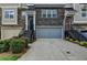 Townhome with a gray garage door, stone accents, landscaped bushes, and stairs leading to the front door at 2719 Hedgeway Cir, Kennesaw, GA 30144