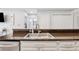 Kitchen view featuring granite counters, a stainless steel sink, and white cabinetry with gold hardware at 3040 Peachtree Rd, Atlanta, GA 30305