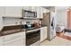Well-lit kitchen with stainless steel appliances, granite countertops, and white cabinetry at 3040 Peachtree Rd, Atlanta, GA 30305