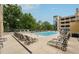 Outdoor pool area surrounded by lounge chairs, offering a relaxing space with greenery and an adjacent parking structure at 3040 Peachtree Rd, Atlanta, GA 30305