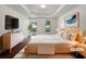 Bright bedroom featuring tray ceilings, large windows, and stylish modern furniture at 643 Windy Mill Way, Temple, GA 30179