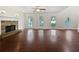 Spacious living room featuring hardwood floors, a ceiling fan, and a stone fireplace at 643 Windy Mill Way, Temple, GA 30179