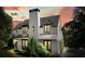 Striking two-story home showcasing a modern facade, a dramatic chimney and lush greenery at 6930 Wesley Hughes Rd, Cumming, GA 30040